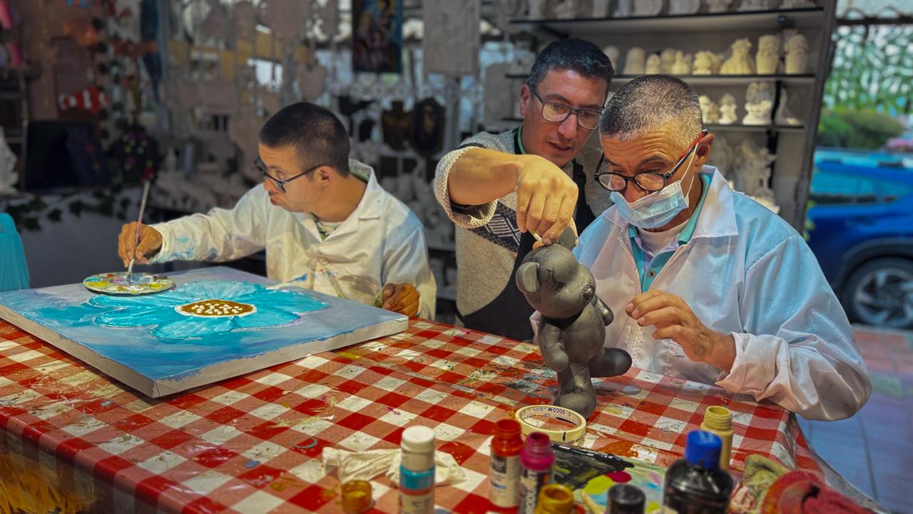 Familia y amigos creando artesanías juntos en un taller acogedor